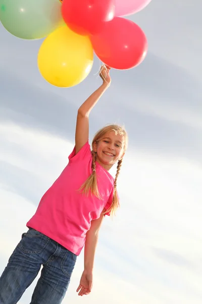 Küçük kız kırsal kesimde balonlar uzatarak — Stok fotoğraf