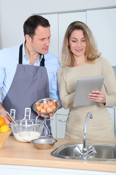 Пара на кухне глядя на рецепт в Интернете — стоковое фото