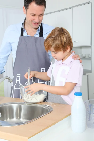 Otec a syn přípravu dortu v kuchyni — Stock fotografie