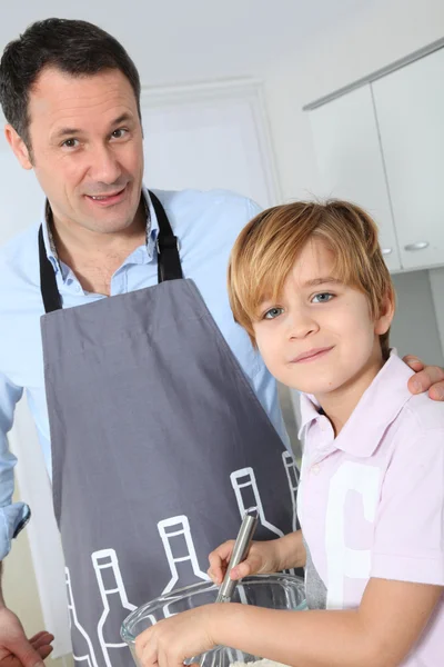 Vader en zoon voorbereiding taart in keuken — Stockfoto