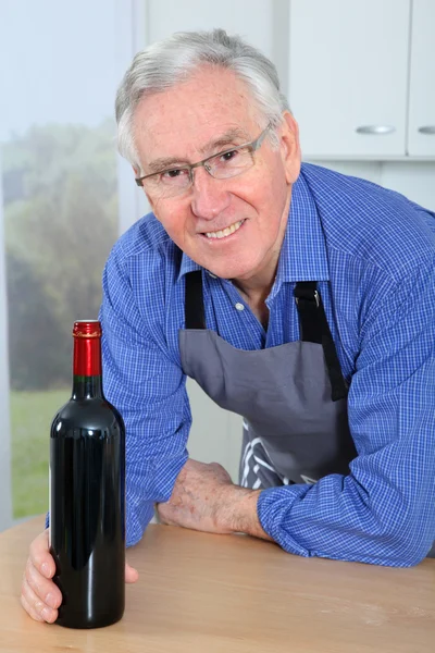 Anciano sosteniendo botella de vino tinto — Foto de Stock