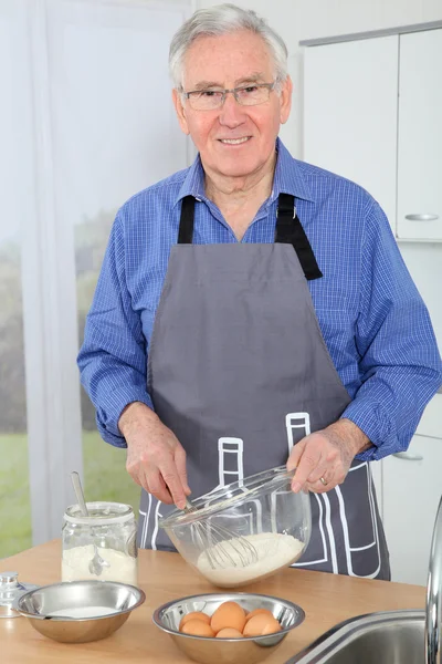 Homem idoso preparando bolo em casa cozinha — Fotografia de Stock
