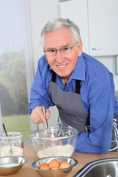 Älterer Mann bereitet Kuchen in der heimischen Küche zu — Stockfoto