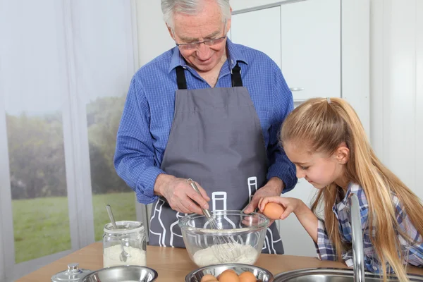 Grandfather with little girl preparing cake — Stock Photo, Image