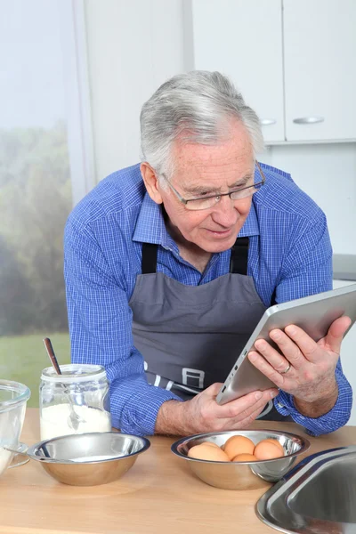 Homem idoso olhando receita na guia eletrônica — Fotografia de Stock