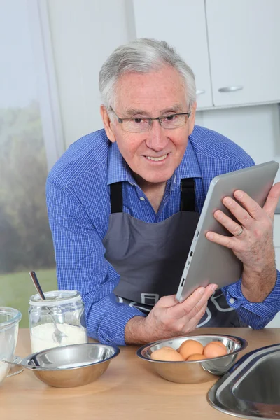 Oudere man kijken recept op elektronische tabblad — Stockfoto