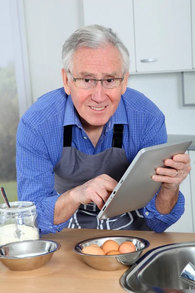 Пожилой человек смотрит на рецепт на электронный счет — стоковое фото