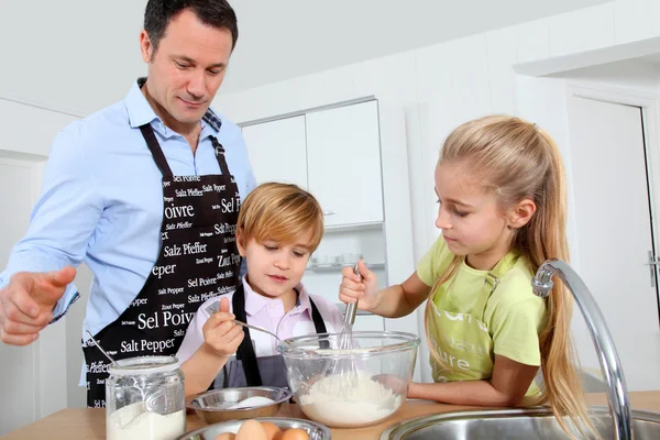 Vater und Kinder bereiten Pfannkuchen zu — Stockfoto