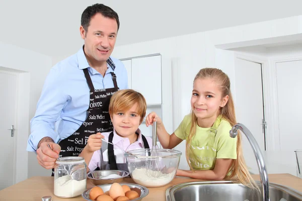 Pai e filhos preparando panquecas — Fotografia de Stock