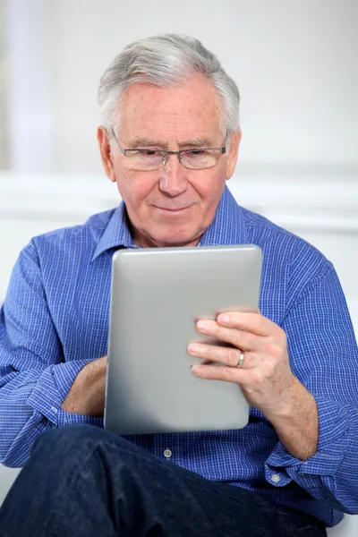 Starší muž, Spojené s elektronickou kartou na internetu — Stock fotografie