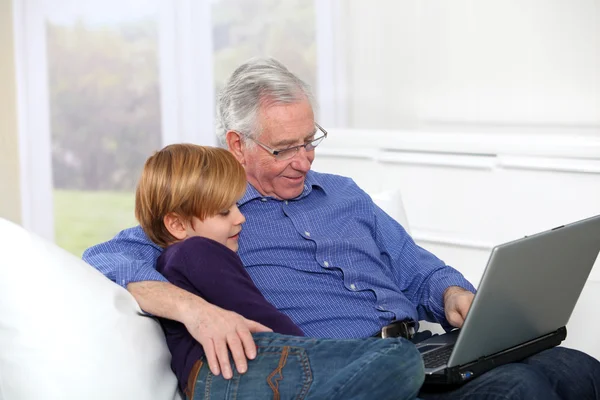 Idős ember grandkid laptop számítógép segítségével — Stock Fotó