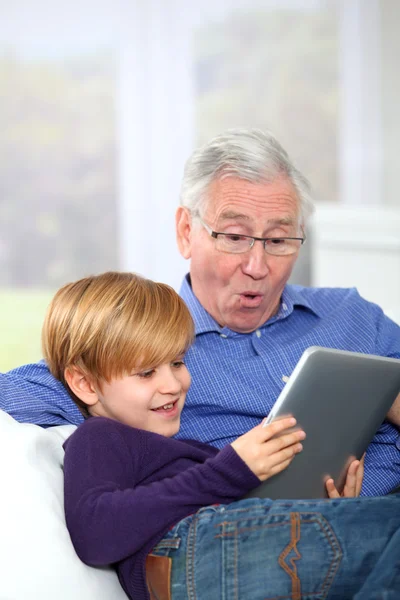Ο παππούς με το μικρό αγόρι χρησιμοποιώντας ηλεκτρονικό, ταμπλετών — Φωτογραφία Αρχείου