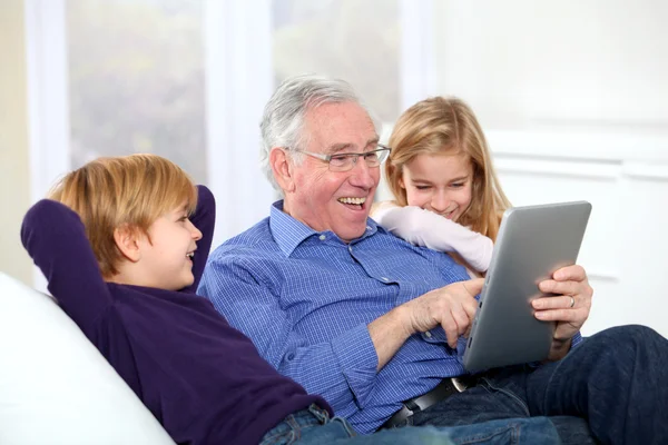 Dziadek z dziećmi za pomocą elektronicznej karty — Zdjęcie stockowe
