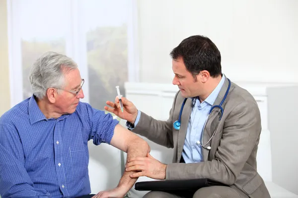 Médico haciendo la vacunación al hombre mayor —  Fotos de Stock