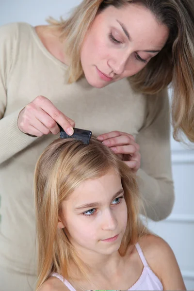 Madre tratando el cabello de su hija contra los piojos — Foto de Stock
