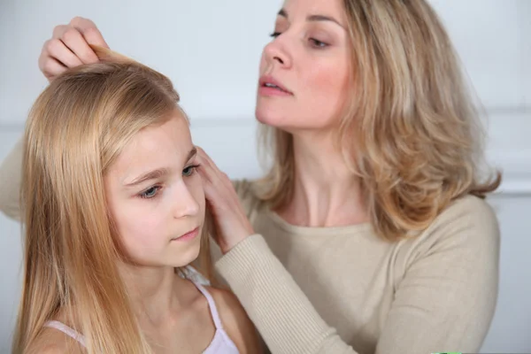 Мать лечит волосы дочери от вшей — стоковое фото
