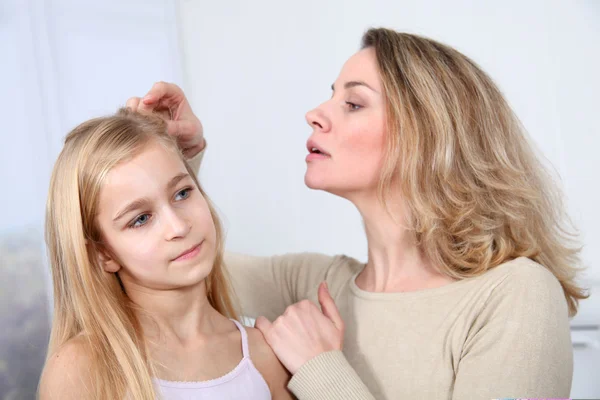 Madre tratando el cabello de su hija contra los piojos — Foto de Stock