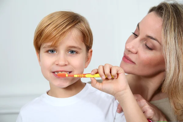 Moeder onderwijs kleine jongen zijn tanden te poetsen — Stockfoto
