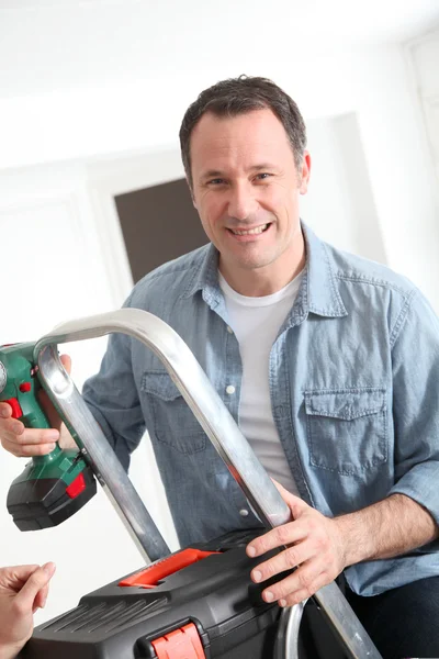 Closeup usmívající se muž s elektrickou vrtačku — Stock fotografie
