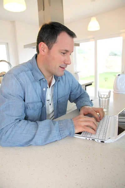 Mutfakta dizüstü bilgisayar kullanan adam — Stok fotoğraf