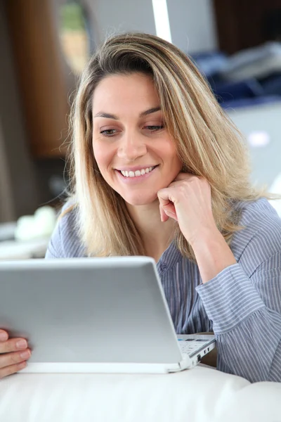 Χαμογελαστή γυναίκα που συνδέονται στο Διαδίκτυο στο σπίτι — Φωτογραφία Αρχείου