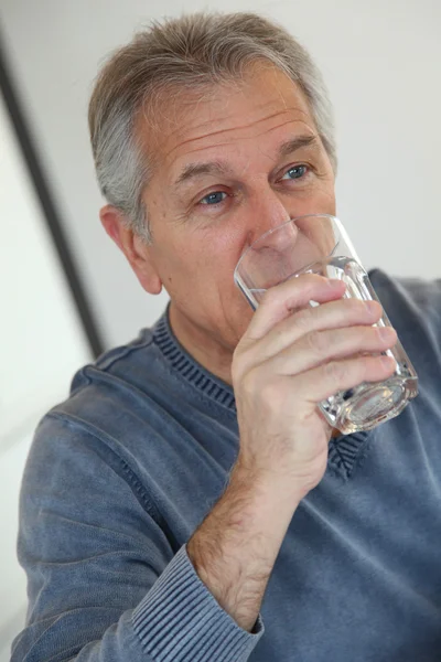 Senior trinkt Glas Wasser — Stockfoto