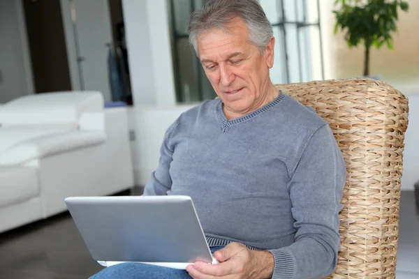 Idősebb ember, szörfözés a internet otthon — Stock Fotó