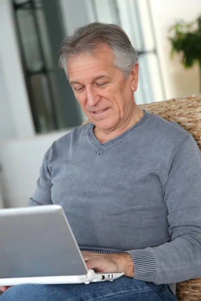 Äldre man surfa på internet i hemmet — Stockfoto