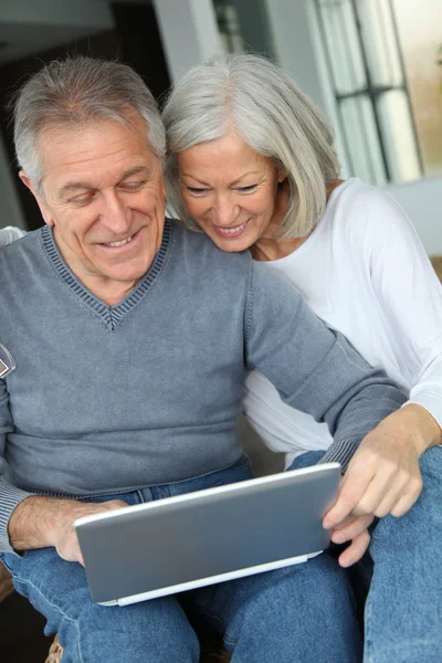 Feliz pareja de ancianos conectados a Internet en casa —  Fotos de Stock