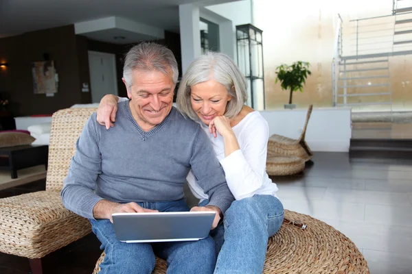 Feliz pareja de ancianos conectados a Internet en casa — Foto de Stock