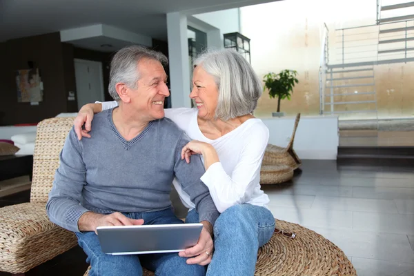 Pasangan senior yang bahagia terhubung di internet di rumah — Stok Foto