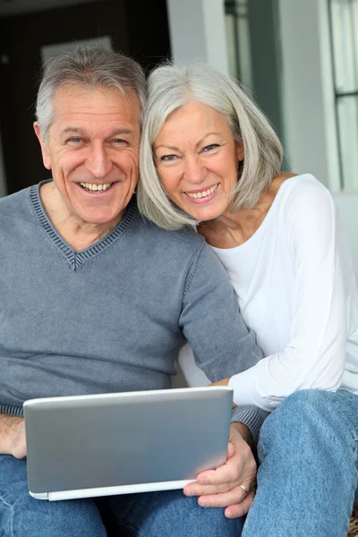 Feliz pareja de ancianos conectados a Internet en casa —  Fotos de Stock