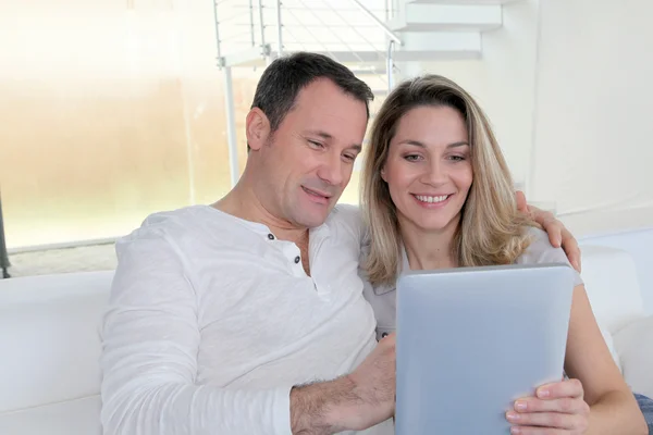 Couple à la maison en utilisant une tablette électronique — Photo