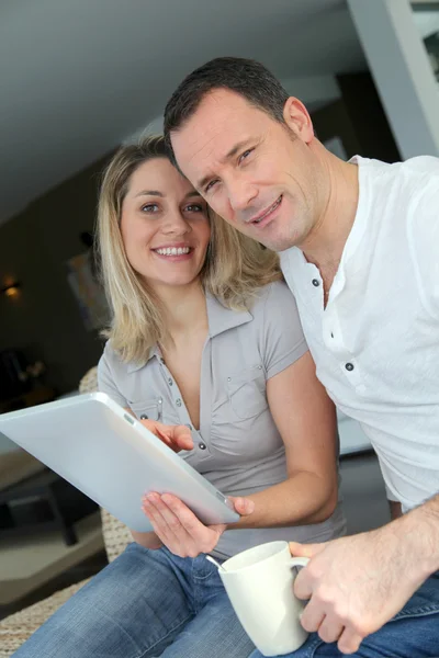 Couple à la maison en utilisant une tablette électronique — Photo