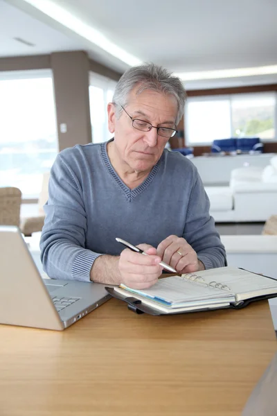 Senior man thuis voor laptopcomputer — Stockfoto