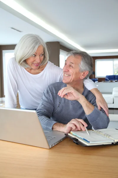 年配のカップルが自宅でインターネット上でサーフィン — ストック写真