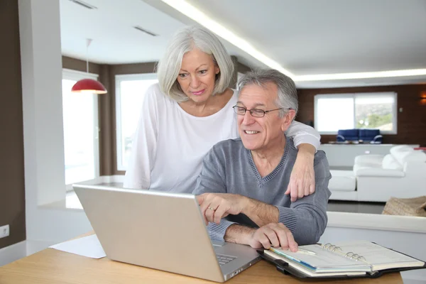 年配のカップルが自宅でインターネット上でサーフィン — ストック写真