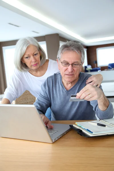 Старша пара, що здійснює безпечну оплату в Інтернеті — стокове фото