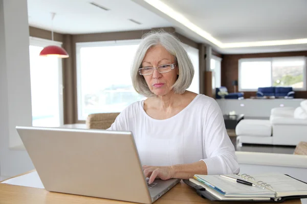 Seniorin zu Hause vor Laptop — Stockfoto