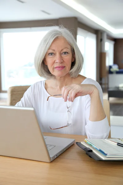 Starszy kobieta w domu przed laptopem — Zdjęcie stockowe