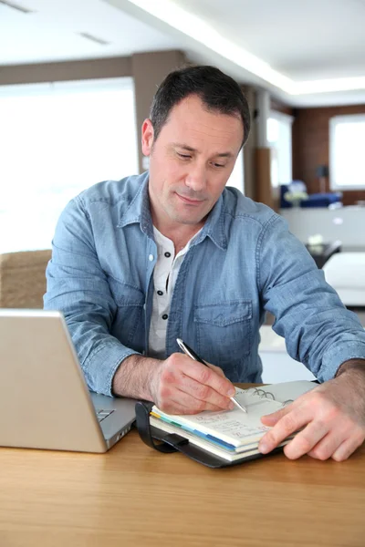 Człowiek pracujący w domu na laptopie — Zdjęcie stockowe