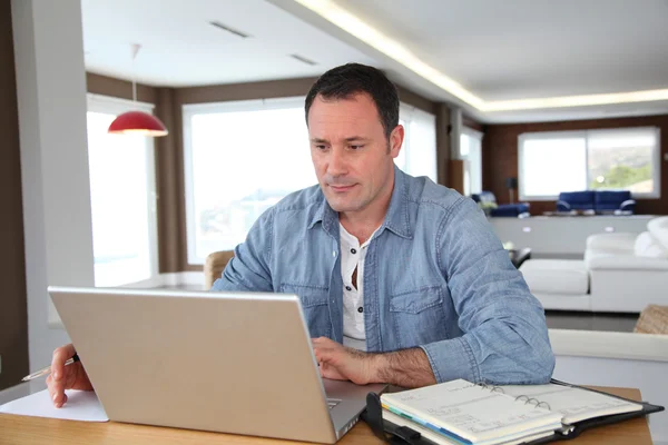 Mann arbeitet zu Hause am Laptop — Stockfoto