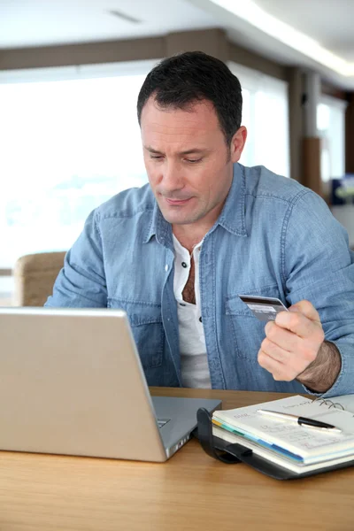 Чоловік перед комп'ютером здійснює онлайн оплату — стокове фото