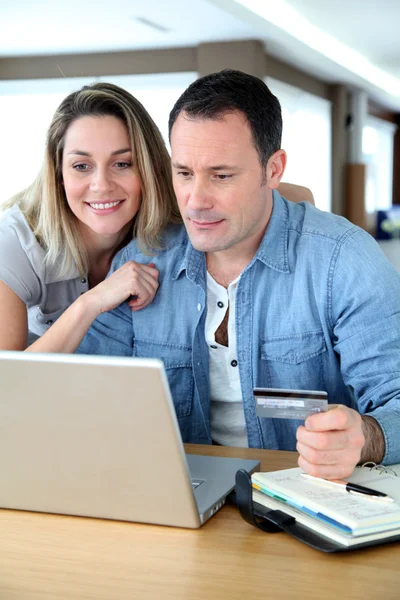 Пара делать онлайн покупки через ноутбук — стоковое фото