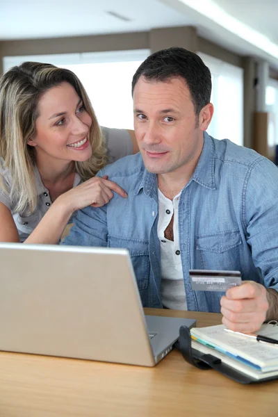 Пара делать онлайн покупки через ноутбук — стоковое фото