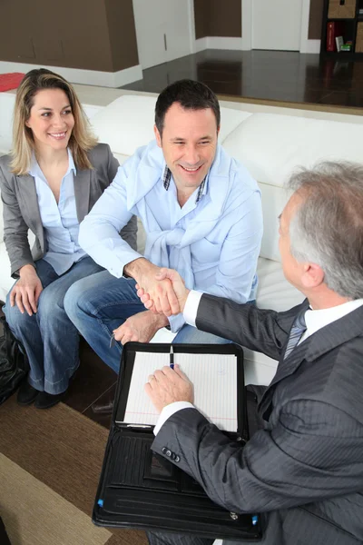 Pareja estrechando la mano a agente de bienes raíces — Foto de Stock
