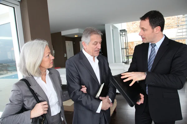 Senior couple visiting modern house with real-estate agent — Stock Photo, Image