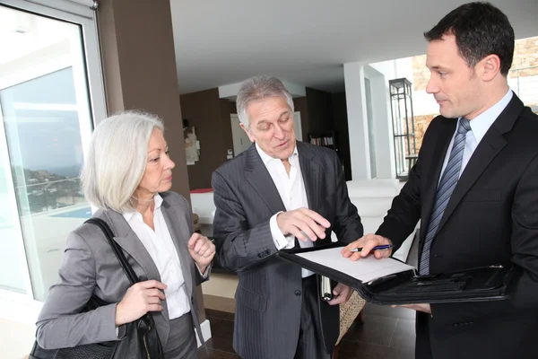 Couple âgé signant un contrat financier pour l'achat d'une propriété — Photo