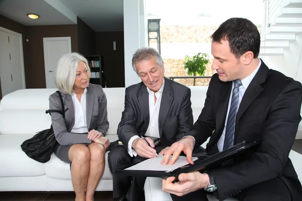Couple âgé signant un contrat financier pour l'achat d'une propriété — Photo
