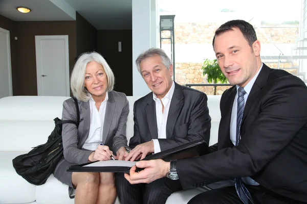 Senior couple signing financial contract for property purchase — Stock Photo, Image